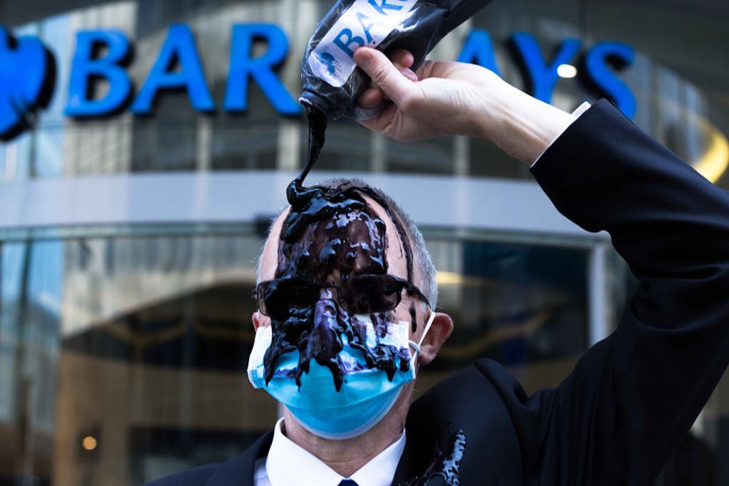 XR Scotland activist Climate activist in suit pours oil over themselves outside a Barcalays bank