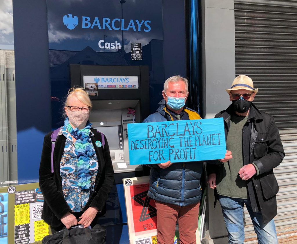 Three Extinction Rebellion Glasgow activists protest outside a Barclays branch