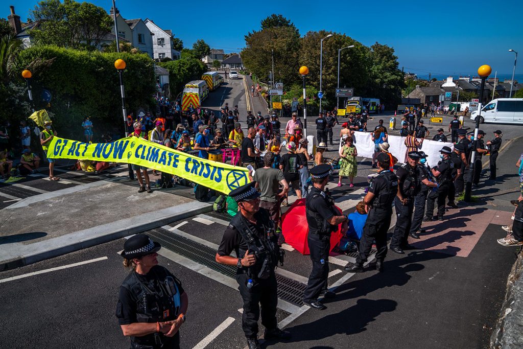 Police form a kettle around protestors and a samba band on a street