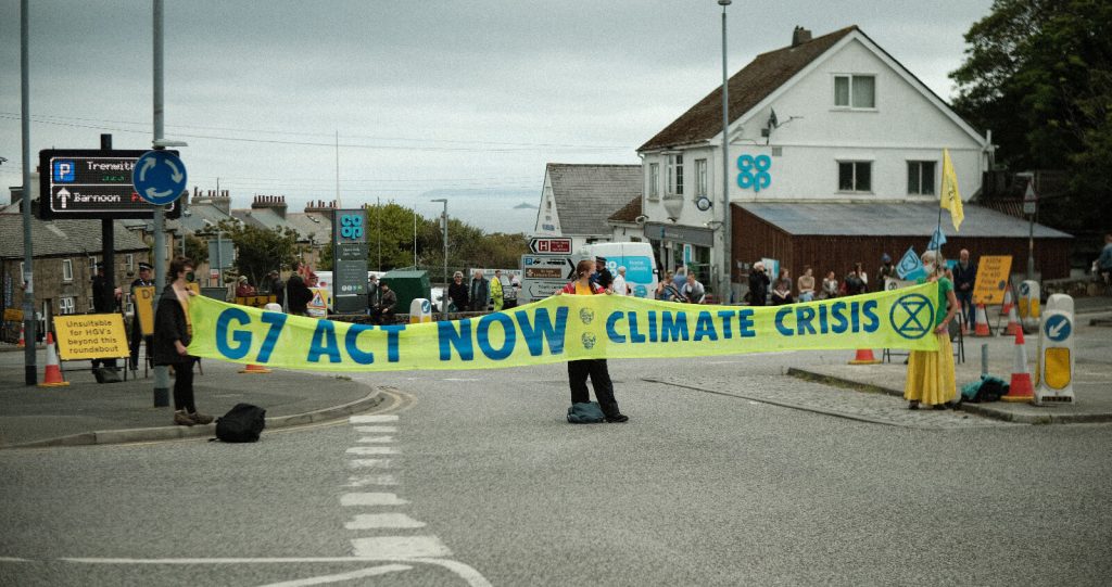 Climate activists hold a banner across a road