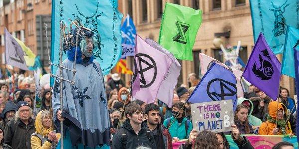 Marching through city with XR banners, flags.